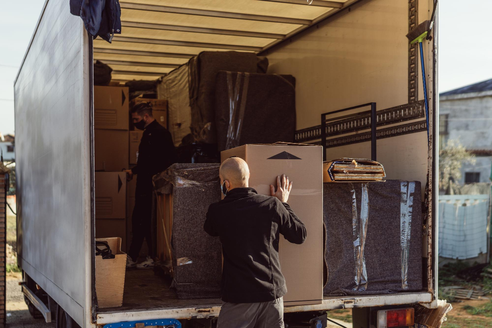 2 men placing bundles inside moving truck